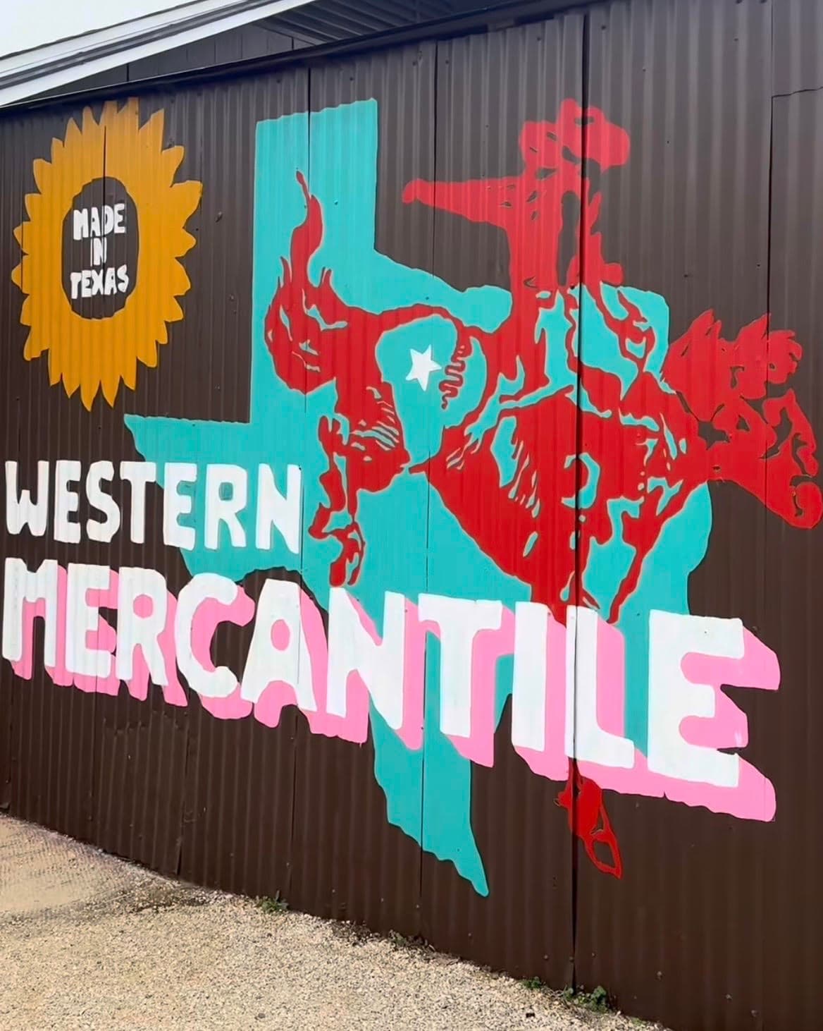 Western Mercantile mural on brown metal featuring a blue Texas outline and red bucking bronco.